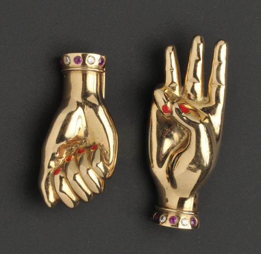 Pair of 14K gold gem-set ‘sign language’ clip brooches, Paul Flato, circa 1938, with red enamel fingernails, ruby and diamond melee accents, length 1 1/2 and 1 7/8 inches, unsigned. Estimate: $5,000-$7,000. Image courtesy of Skinner Inc.