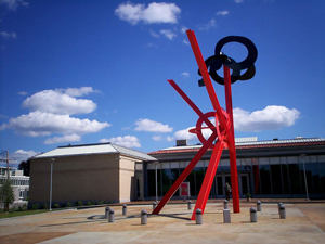 Exterior view of the Currier Museum of Art in Manchester, N.H. In the foreground is the sculpture title 'Origins,' by Mark di Suvero. June 2, 2008 photo taken by Struthious Bandersnatch. Licensed under the Creative Commons Attribution-Share Alike 3.0 Unported license.