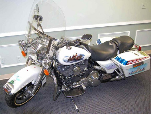 2000 Harley Davidson Road King Police Special Motorcycle, custom painted with patriotic scenes, originally from the 2000 Summer Olympics and was an Official Escort Model with 6 kilometers on the odometer. Estimate: $10,000-$15,000. Image courtesy of Four Seasons Auction Gallery.
