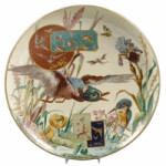 Fish, birds, a crayfish, moth, dragonfly, kingfisher, duck, water lilies and iris are all part of the foliage and scenery on this aesthetic plate. The 17 1/2-inch charger was made in France by Barluet & Cie and recently sold at a Skinner auction in Boston for $1,007.