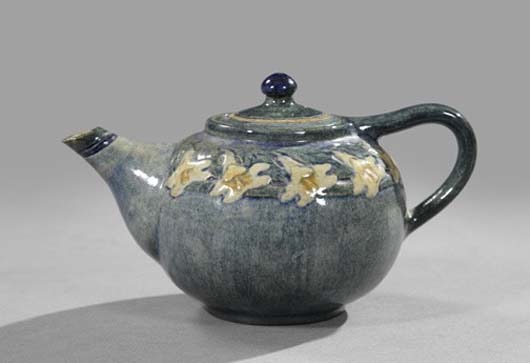 Early Newcomb College Pottery high-glaze ‘Solitaire’ teapot, 1908, in Lily decor, potted by Joseph Fortune Meyer (1848-1931) and decorated by Anna Frances Simpson (d. 1930), 3 1/2 inches high, 4 inches wide, 7 inches long. Estimate: $2,000-$4,000. Image courtesy of New Orleans Auction, St. Charles Gallery.