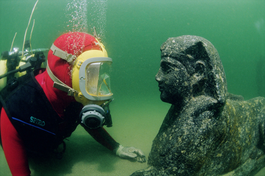 A diver examines a sphinx made of black granite. The face of the sphinx is believed to represent Ptolemy XII, father of the famous Cleopatra VII. It was found during excavations in the ancient harbor of Alexandria. © Franck Goddio/Hilti Foundation, photo: Jerome Delafosse.