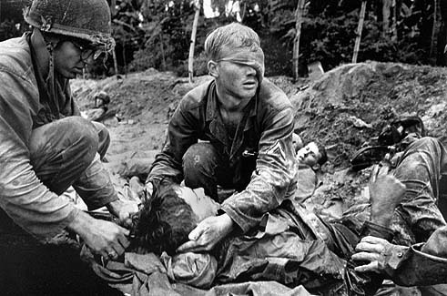 One of Henri Huet's series of photographs featuring medic Thomas Cole tending to wounded American soldiers, 1966. Fair use of assumed-copyrighted historically significant and unique image sourced from The Digital Journalist to illustrate the subject of the article it accompanies. No alternative, public domain or copyright-free replacement image is available. Image must not be copied to linked to.