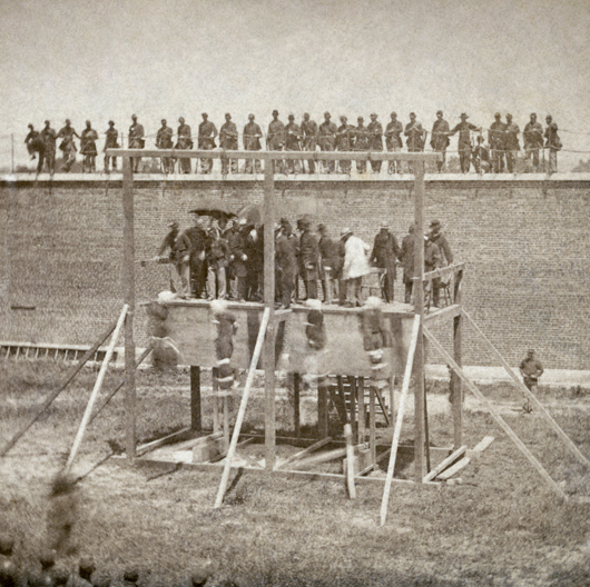 Four Lincoln assassination conspirators swing from the gallows on July 7, 1865 at Fort McNair in Washington, D.C. Image courtesy of Wikimedia Commons.