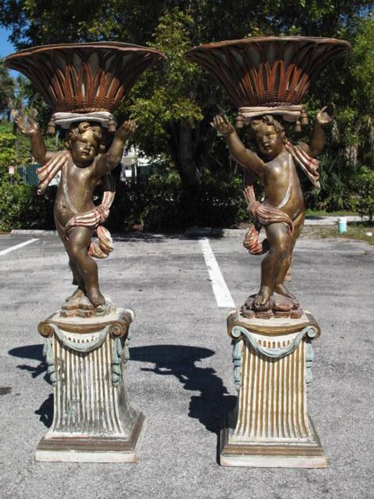 Pair of rare, latter 19th-century Venetian parcel gilt and polychrome painted wood putti, each 57 inches tall and supporting a reticulated carved wood cache pot with original tole liners. Estimate for pair $7,000-$9,000. Auctions Neapolitan image.