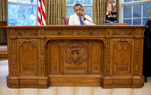President Barack Obama seated behind the original Resolute Desk. Image courtesy of Wikimedia Commons.
