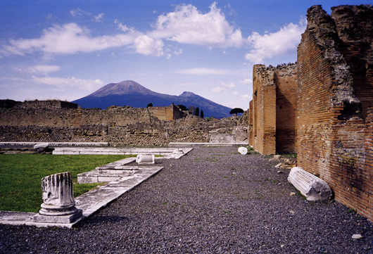 Mount Vesuvius as seen from the ruins of Pompeii, which was destroyed in the eruption of AD 79. The active cone is the high peak on the left side. Image courtesy of Wikimedia Commons.