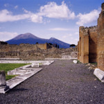 Mount Vesuvius as seen from the ruins of Pompeii, which was destroyed in the eruption of AD 79. The active cone is the high peak on the left side. Image courtesy of Wikimedia Commons.