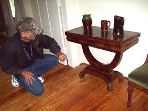 Fred takes a closer look at a Late Classicism game table. The ranger did not know it opened up and swiveled to provide  a playing surface.