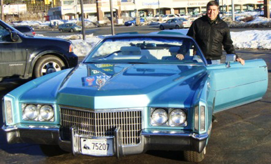 Auctioneer Tim Chapulis poses alongside a gleaming 1971 Cadillac convertible with less than 59,000 miles. Image courtesy of Tim’s Inc.