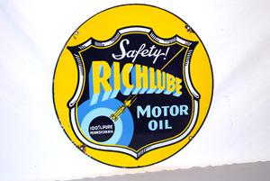 The sale's top lot was this Richlube double-sided porcelain sign with race car graphic. In near-mint condition it sold for $7,425. Image courtesy of Matthews Auctions LLC.