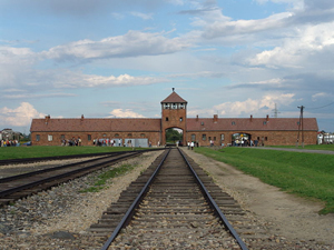 View of the main gate at former Nazi death camp of Birkenau. August 2006 photo by Angelo Celedon, licensed under the Creative Commons Attribution-Share Alike 2.5 Generic license.
