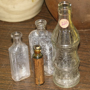 The empty bottles left and center are from Crystal Pharmacy in Pensacola and D'Alemberte's Pharmacy, Pensacola, respectively. The tall soda pop bottle is marked ‘Drink Try-Me’ and is from Northport, Ala. Image courtesy of LiveAuctioneers Archive and Flomaton Antique Auction.