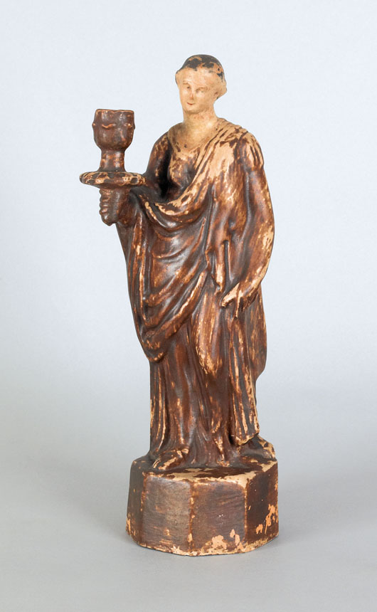  This redware candlestick in the form of a classically garbed woman is marked by the potter, Solomon Bell of Strasburg, Pa. The formal piece, influenced by fine ceramic figures from Europe, brought $23,700 last fall. Image courtesy of Pook & Pook.