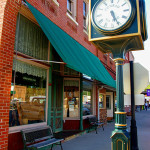 A quaint and locally revered stretch of downtown Conrad, Iowa that includes the Conrad General store, with white lace curtains green awning. Image courtesy of City of Conrad, Iowa.
