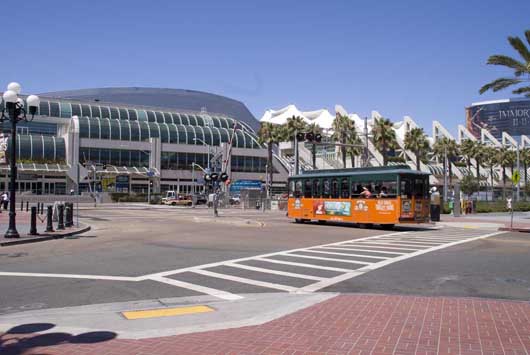 A tour bus in the form of a trolley rolls by the front of the San Diego Convention Center on Tuesday. Inside, frantic preparations for Comic-Con International: San Diego were under way. Photo by Michael A. Solof.