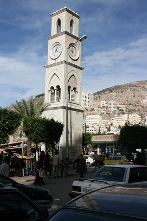A clock tower and adjacent tourist center are at Ash-Shuhada Square in downtown Nablus. Image by Tiamat. This file is licensed under the Creative Commons Attribution-Share Alike 3.0 Unported license.