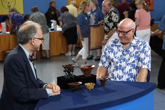 Expert Lark Mason (left) breaks the good news to the anonymous owner of the Chinese rhino-horn cups that his mini trove is worth $1-$1.5 million. Image copyright Antiques Roadshow, used by permission.