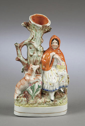 Little Red Riding Hood is standing near a vase meant to hold 'spills' (thin wooden sticks or rolled paper) used to transfer a flame from a fireplace or stove to a candle or lamp. The 10 1/2-inch-high figure made in the Staffordshire district of England in about 1850 sold for $110 at Cowan's Auctions in Cincinnati.