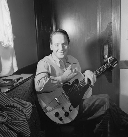 Circa 1947 photograph of Les Paul playing a 1942 Les Paul electric guitar he called 'Clunker.' Photo taken by William P. Gottlieb.