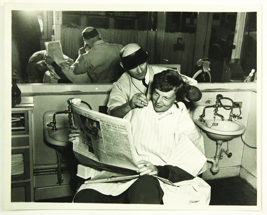 Preparing for her global flight, Earhart is pictured getting her hair cut at a barbershop. Image courtesy of Clars Auction Gallery.