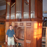 Raymond Brunner stands beside the restored 1770 Tannenberg organ. Image courtesy of R.J. Brunner & Co.