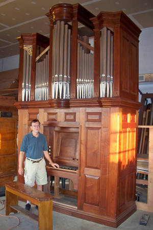 Raymond Brunner stands beside the restored 1770 Tannenberg organ. Image courtesy of R.J. Brunner & Co.
