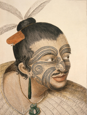 Head and shoulders portrait of a tattooed Māori chief seen by Capt. Cook and his men. Hair is in a topknot with feathers and a bone comb, displays full facial moko, a greenstone earring, a tiki and a flax cloak. He has a small beard and a moustache. Probably sketched in 1769; artwork published in 1784. From the Alexander Turnbull Library.