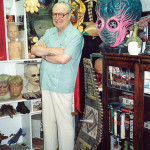 The late Forrest J. Ackerman, surrounded by part of his collection at the 'Ackermansion.' Image courtesy of Wikimedia Commons.