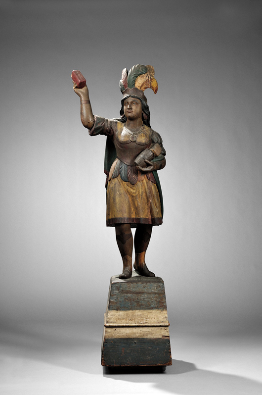 Carved and Painted Indian Princess Tobacconist Figure, attributed to Samuel Robb (1851-1928), New York, New York, c. 1880, on original base, old painted surface, (imperfections), figure ht. 56, overall ht. 80 in. Provenance: Acquired from the Estate of Helena Penrose, New York, New York. Other trade figures formerly in the collection of Helena Penrose were sold at Christie's in October, 2007. Estimate $30,000-50,000. Sold for $71,100.