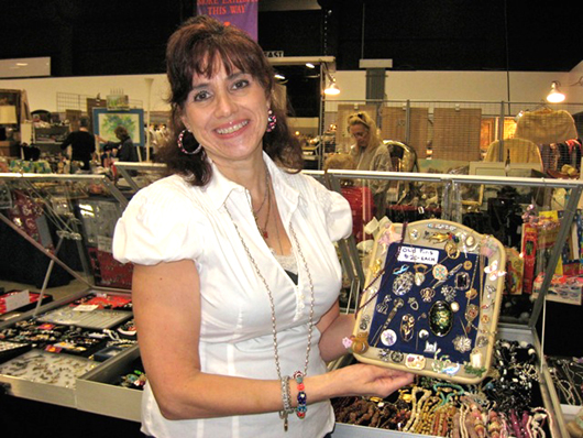 Tammy Vingo holds some of her 'fun' jewelry. Image courtesy of West Palm Beach Antiques Festival.