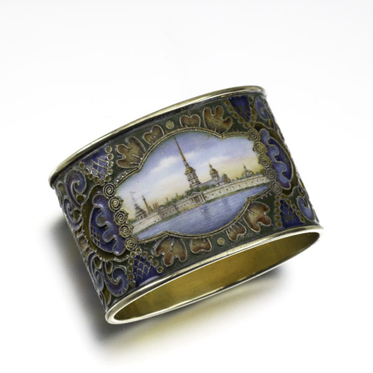 Faberge scenic enameled silver napkin ring, ca.1900.Oval with traditional cloisonné motif, en plein biscuit enamel plaque depicts the Fortress of Saint Peter and Saint Paul. Estimate: $6,000-$8,000. Image courtesy of Rago Arts and Auction Center.