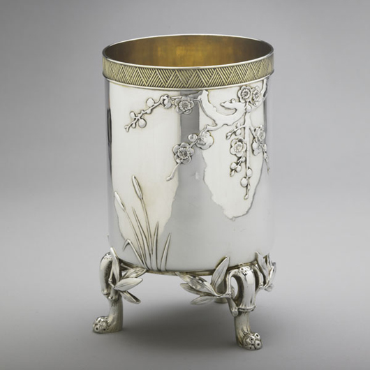 Tiffany & Co. Japanesque parcel gilt vase, circa 1874, cylindrical form on bamboo branch and foliage feet, 6.7 inchs x 3.9 inches. Estimate: $1,200-$1,800. Image courtesy of Rago Arts and Auction Center.