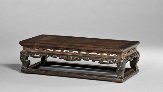 Zitan Kang table/stand, China, 17th/18th century, pierced waist, pierced and carved archaic motif apron, with flat stretchers, height 7 1/4 inches, top 24 3/4 x 11 in. Estimate $600-$800. Image courtesy of Skinner Inc.  