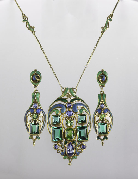 Frank Gardner Hale jeweled and enameled bold Arts and Crafts suite, circa 1920. A pendant necklace and earrings composed of a principal demantoid garnet, blue-green tourmalines and sapphires arranged among 18K gold fronds in shades of blue and green guilloche enamel. Estimate: $30,000-$40,000. Rago Arts and Auction Center.   