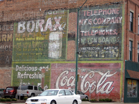 Several ghost signs on a building in Fort Dodge, Iowa. Image by Bill Whittaker, courtesy of Wikimedia Commons.
