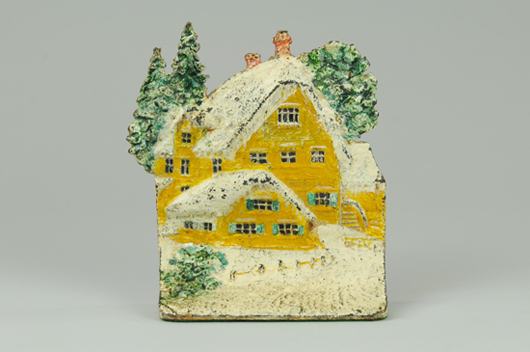 Hand-painted cast-iron doorstop depicting snow-capped cottage, book example, $5,175. Bertoia Auctions image.
