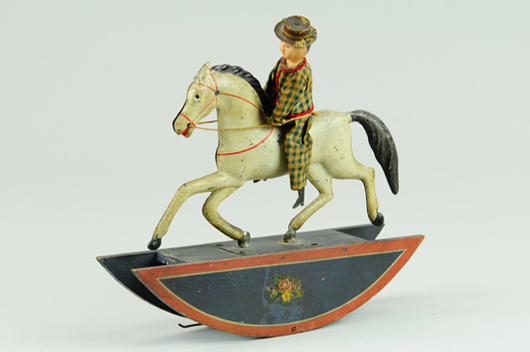 Top American toy lot of the sale: Ives cloth-dressed man on tin rocking horse, ex Tom Anderson collection, $39,100. Bertoia Auctions image.