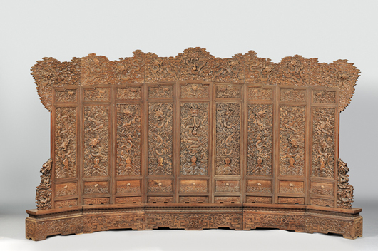Large screen elaborately carved wood in twenty-one sections, both front and back carved with dragons coiling above Mount Penglai and waves, 175 inches wide, 102 inches high. Realized: $45,563. 