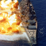 The battleship USS IOWA firing its 16-inch guns during a firepower demonstration in August 1984. Image courtesy of Wikimedia Commons.