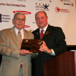 Jack Ogle (left) is presented his Texas Auctioneers Association Hall of Fame plaque in 2010 by Mike Jones. Image courtesy of the Texas Auctioneers Association.