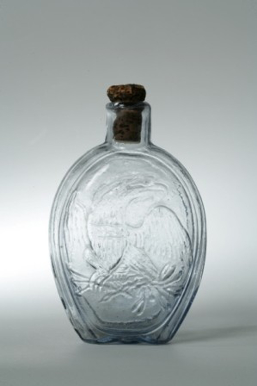 This rare blown flask is clear glass having a blue tint and pictures a bust of Columbia on one side and an American Eagle on the reverse. The 7-inch-tall flask has a $5,000-$10,000 estimate. Image courtesy of Keno Auctions.