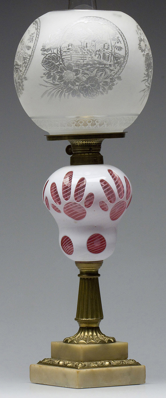 Cut overlay bear paw stand lamp, opaque with cut to cranberry pyriform font. October sale: $9,200. Image courtesy of Jeffrey S. Evans & Associates.