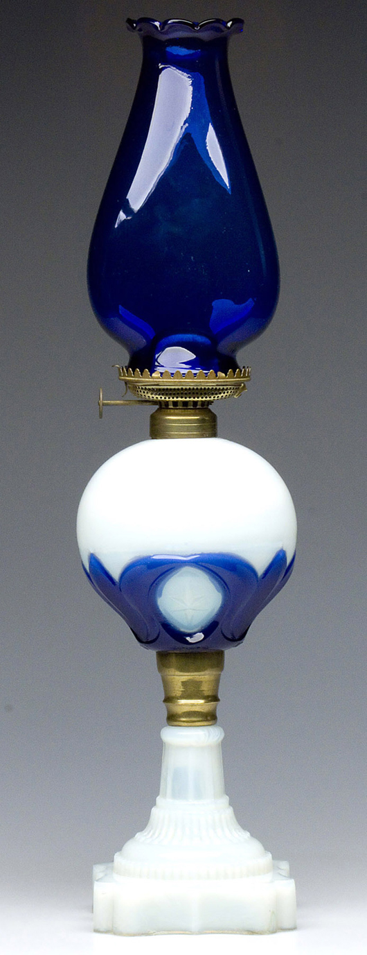 Nineteenth-century Tulip and Star stand lamp in an opalescent and cobalt blue font. October sale: $5,462. Image courtesy of Jeffrey S. Evans & Associates.