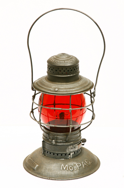 This MoPac (Missouri Pacific) railroad lantern with ruby-colored glass is one of approximately 160 lanterns from various train lines in the Roy Gay collection. A&S image.
