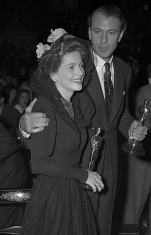 Actors Joan Fontaine and Gary Cooper holding their Oscars at the Academy Awards party in 1942. Image courtesy Wikimedia Commons.