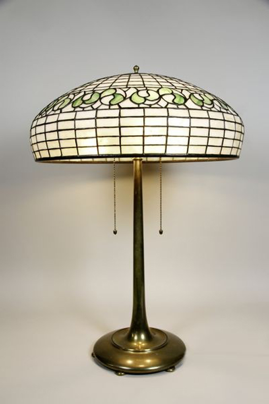 Bigelow Kennard leaded glass table lamp, marked ‘Bigelow Studios’ and ‘Bigelow Kennard Company Boston’ on shade, cast bronze base, 26 1/2 inches high, 18 1/2-inch-diameter shade. Estimate: $2,500-$3,500. Image courtesy Kaminski Auctions.   