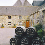 Whisky barrels in the courtyard of Glenfiddich Distillery, Dufftown, Scotland. Note the distinctive pagoda cap on the distillery roof to release the 'aromas.' Photo by Colin Smith, licensed under the Creative Commons Attribution-Share Alike 2.0 Generic license.