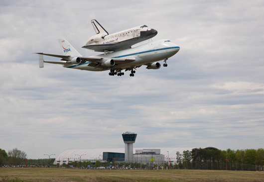 Space shuttle Discovery, mounted atop a NASA 747 Shuttle Carrier Aircraft (SCA) flies over the Steven F. Udvar-Hazy Center, Tuesday, April 17, 2012, in Washington. Discovery, the first orbiter retired from NASA’s shuttle fleet, completed 39 missions, spent 365 days in space, orbited the Earth 5,830 times, and traveled 148,221,675 miles. NASA has transferred Discovery to the National Air and Space Museum to begin its new mission to commemorate past achievements in space and to educate and inspire future generations of explorers. Photo Credit: (NASA/Smithsonian Institution/Dane Penland)