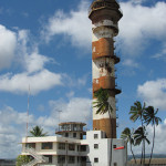 The air traffic control tower (which was, in fact, a water-filled submarine-escape training tower) at the former Naval Air Station, Ford Island, located within Pearl Harbor, Hawaii. Photo by LovesMacs, licensed under the Creative Commons Attribution-Share Alike 3.0 Unported license.